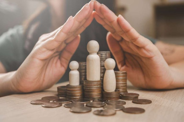 Hands sheltering money and wooden figures representing how a holding company can provide asset protection and creditor isolation