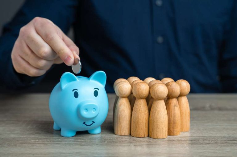 Piggy bank and wooden figures representing federal grants for businesses affected by tariffs